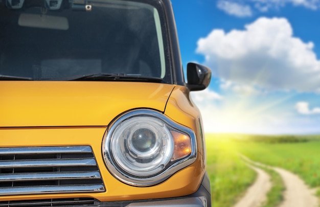 Un coche amarillo con un cielo azul de fondo.