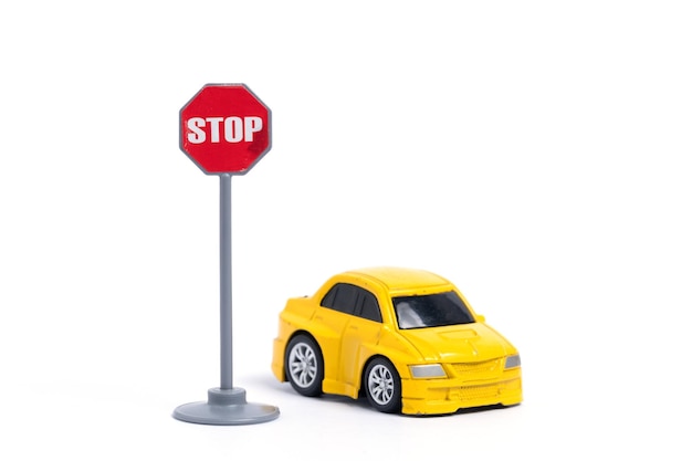 Coche amarillo con señal de parada aislada sobre un fondo blanco