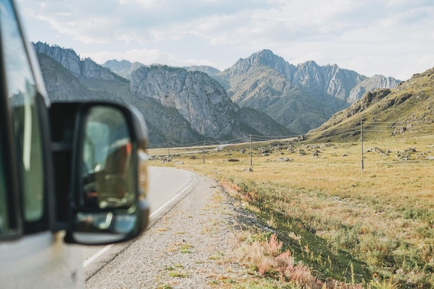 Coche aparcado en la carretera automática contra el hermoso paisaje montañoso Chemalsky tract Altai