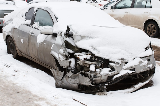 Coche aplastado bajo la nieve en la carretera de invierno