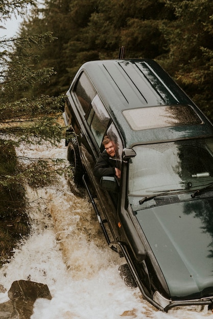 Foto coche atascado en un arroyo de montaña durante un viaje por carretera todoterreno