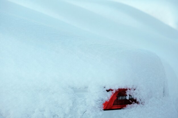 Coche blanco cubierto de nieve y su lámpara trasera roja fondo de invierno escocés