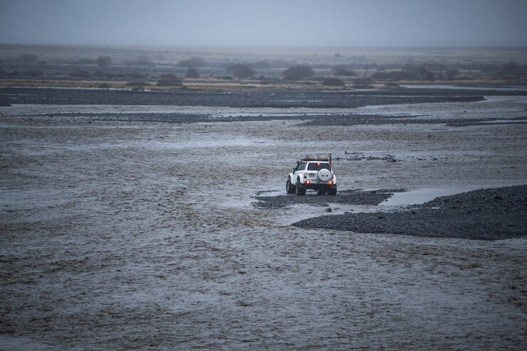 Un coche blanco decidiendo cruzar el río.
