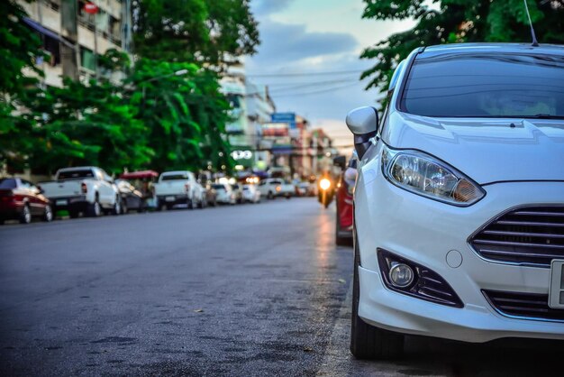 Foto coche blanco estacionado en la calle en la ciudad durante el atardecer