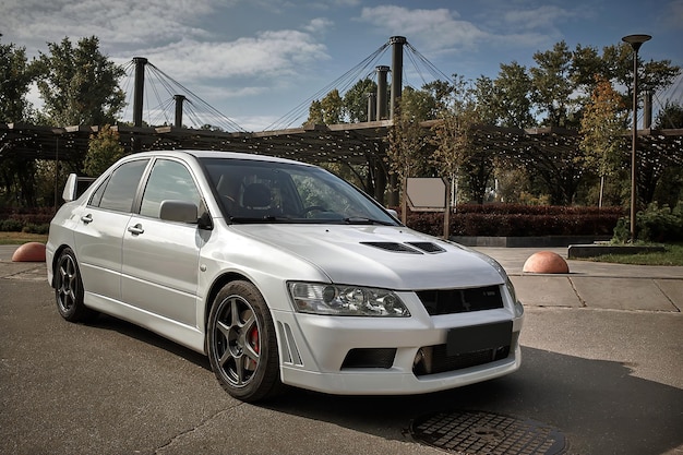 Foto coche blanco en un fondo de calle coche deportivo moderno de la ciudad con un papel pintado de spoiler