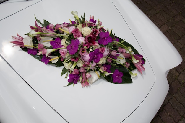 Coche de boda blanco vintage decorado con flores moradas