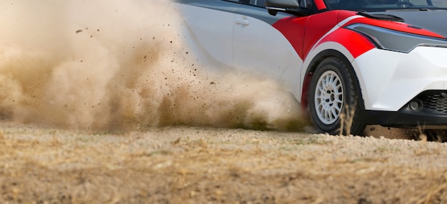 Coche de carreras de rally a la deriva en pista de tierra.