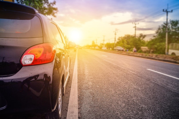 Foto coche en la carretera contra el cielo durante la puesta de sol