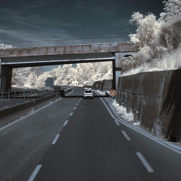 Foto coche en la carretera debajo del puente