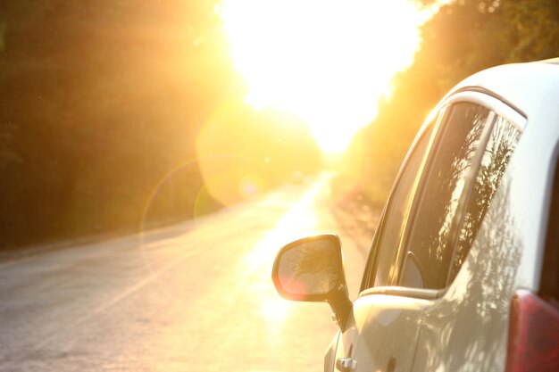 Coche en la carretera con puesta de sol