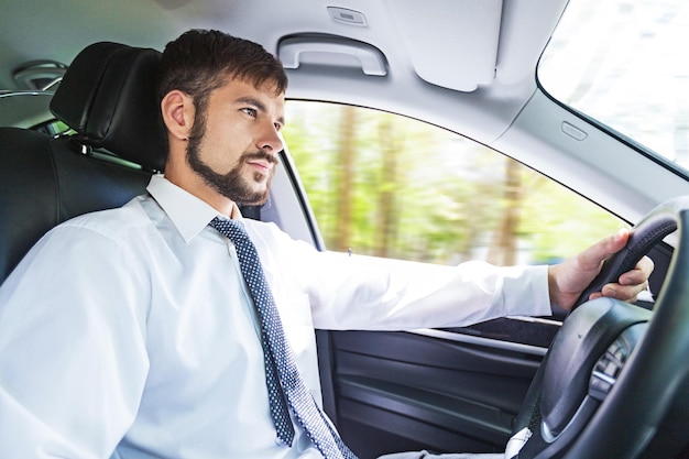 Coche de conducción de hombre de negocios guapo joven