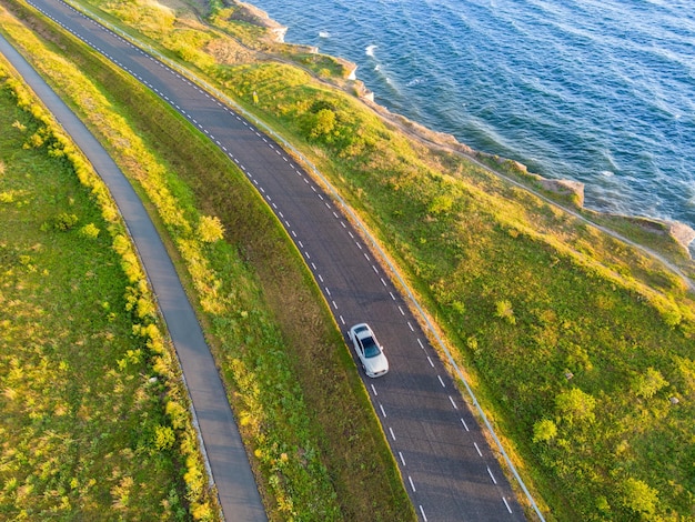 Un coche conduce a lo largo de la carretera cerca del acantilado de Paldiski en un día de verano como se ve desde un avión no tripulado Foto de alta calidad