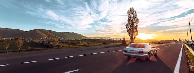 Foto coche conduciendo en la autopista al atardecer