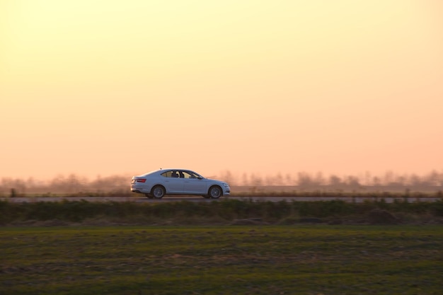 Coche conduciendo rápido por carretera interurbana al atardecer Tráfico de autopista por la noche