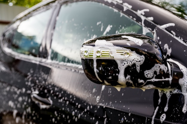 Coche cubierto por agua y jabón.