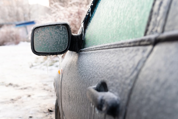 Coche cubierto de corteza de hielo después de una lluvia helada