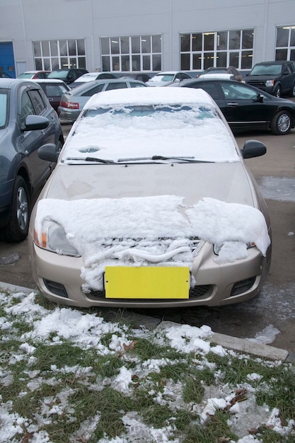 Coche cubierto de nieve en la calle con una etiqueta amarilla en lugar del número