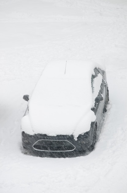 Foto el coche está cubierto de nieve, ciclón de nieve, blizzard. tormenta el concepto de mal tiempo.