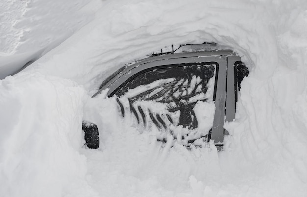 Coche cubierto de nieve después de una fuerte tormenta de nieve