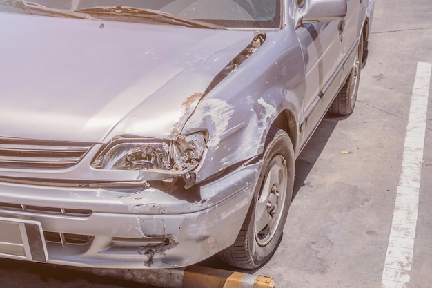 Foto coche dañado en el frente causado por un accidente automovilístico en la carretera