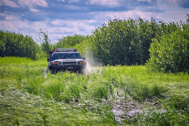 Coche deportivo con tracción total sale de la trampa rociando agua