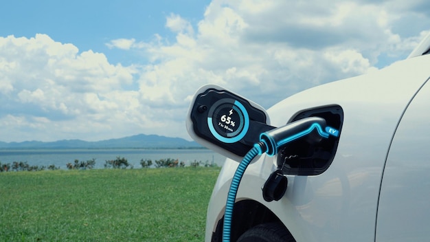 Foto coche eléctrico conectado con estación de carga con fondo de naturaleza peruse