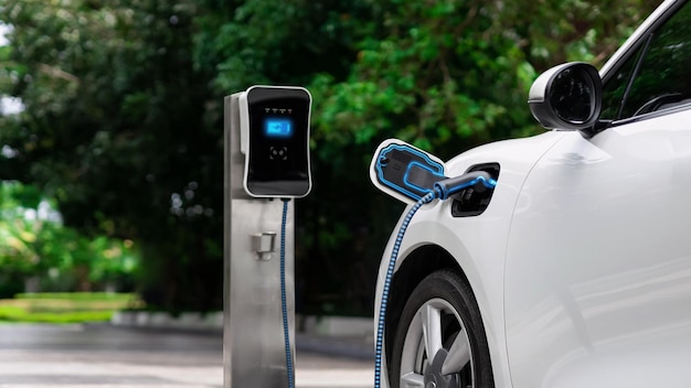 Foto coche eléctrico enchufado con estación de carga en eco green park lea detenidamente