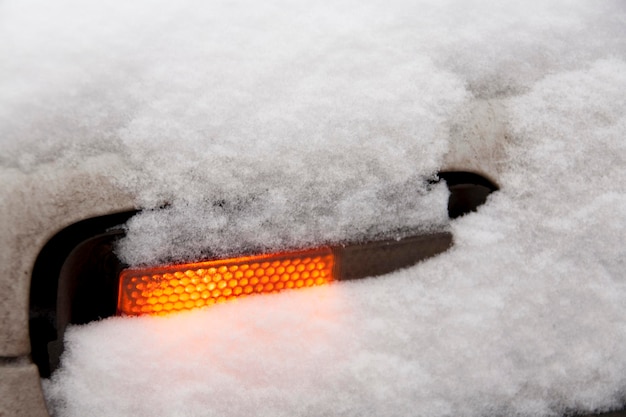 El coche enciende una lámpara roja en la nieve