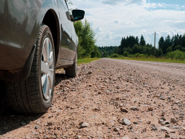 Coche se encuentra en un polvoriento camino rural, rueda de cerca