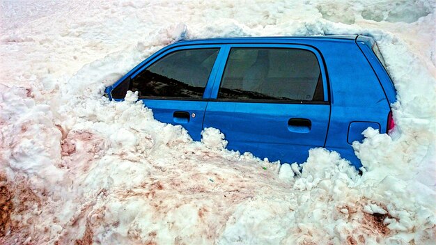 Foto el coche enterrado en la nieve.