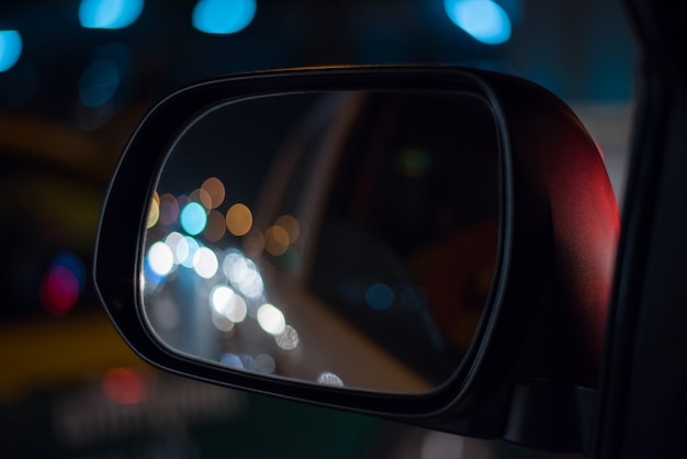 Coche del espejo de la izquierda en la noche de la ciudad