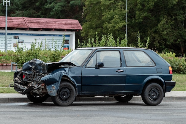 El coche está aparcado después del accidente, el capó está roto, las consecuencias de la falta de atención en las carreteras.