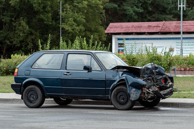 El coche está aparcado después del accidente, el capó está roto, las consecuencias de la falta de atención en las carreteras.