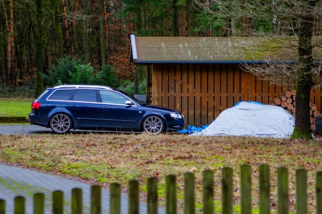 El coche está estacionado cerca de un garaje de madera Alemania foto de alta calidad