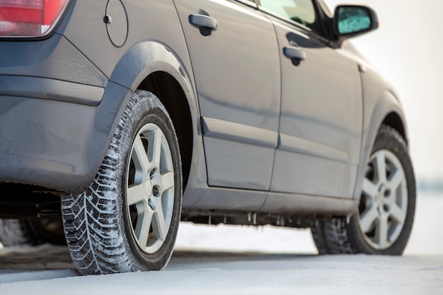 Coche estacionado en el camino cubierto de nieve en día de invierno. Transporte, diseño de vehículos y concepto de seguridad.