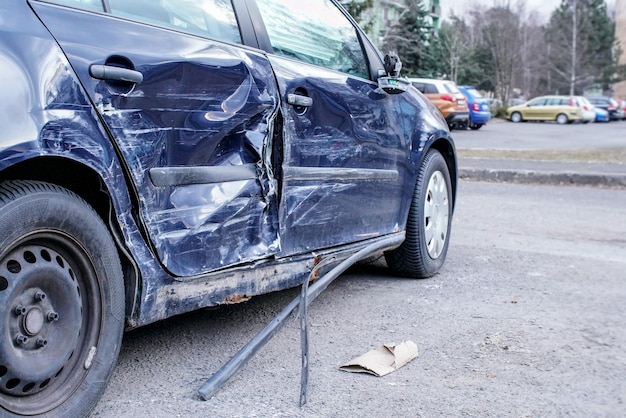 Coche estrellado tras accidente, detalle en el lateral - placas de metal deformadas.