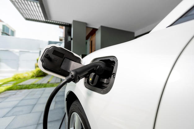 Coche EV enchufado con cable desde la estación de carga doméstica progresiva