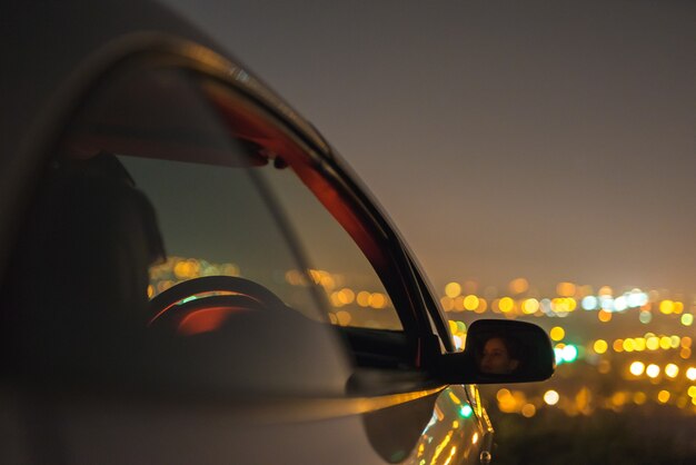 El coche en el fondo de las luces de la ciudad. tarde noche