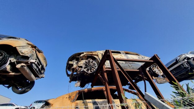 Un coche en una grúa con un cielo azul detrás