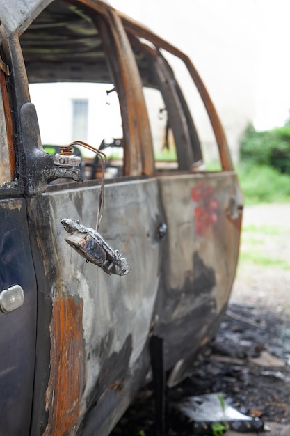 Foto coche tras un incendio coche oxidado quemado tras incendio o accidente coche tras el incendio delito de vandalismo disturbios incendio de coche accidente en la carretera por exceso de velocidad explosión
