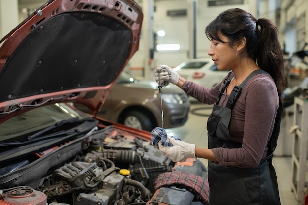 Coche de inspección mecánica femenina en el taller