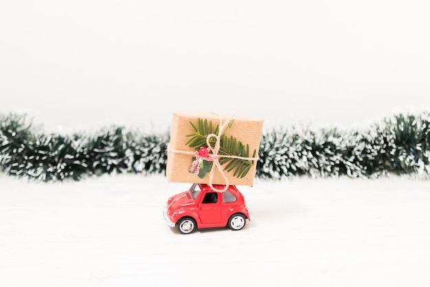 Coche de juguete con caja de regalo cerca de oropel.