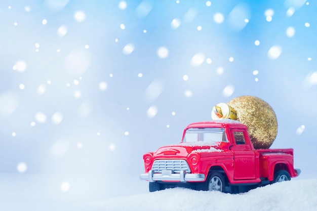 Coche de juguete y decoración de árbol de Navidad en la parte trasera. composición navideña