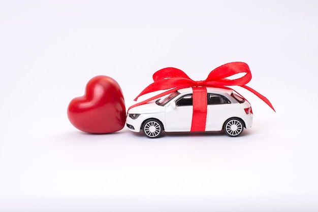 Coche de juguete con lazo de cinta corazón rojo