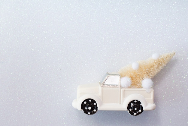 Coche de juguete de Navidad con abeto en blanco