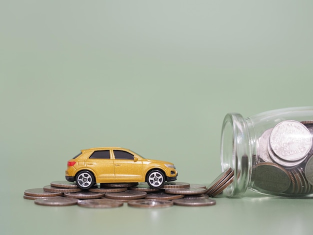 Coche de juguete y pila de monedas El concepto de ahorrar dinero y gestionar el éxito del negocio de transporte