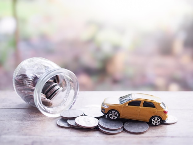 Coche de juguete en una pila de monedas El concepto de ahorrar dinero y manejar para el éxito del negocio de transporte