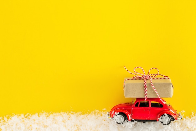 Coche de juguete rojo con una caja de regalo de Navidad,