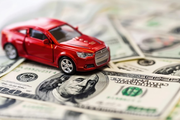 Un coche de juguete rojo sentado encima de una pila de dinero