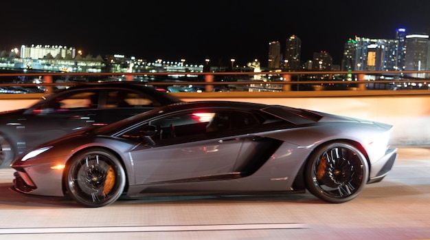 Coche de lujo en movimiento en la ciudad de noche